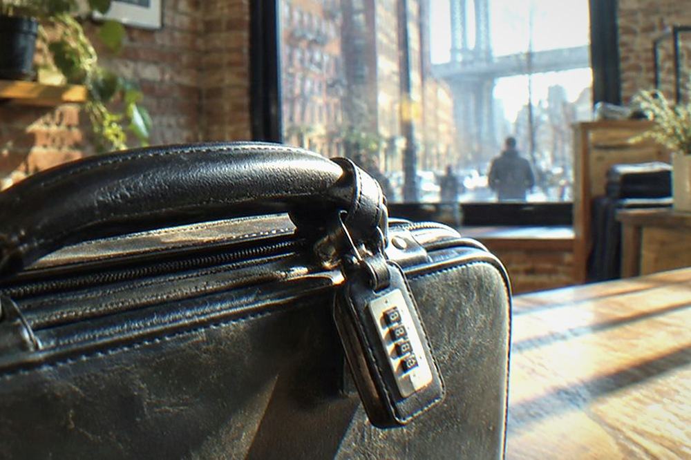 A closed suitcase with a numbered security tag attached to the handle
