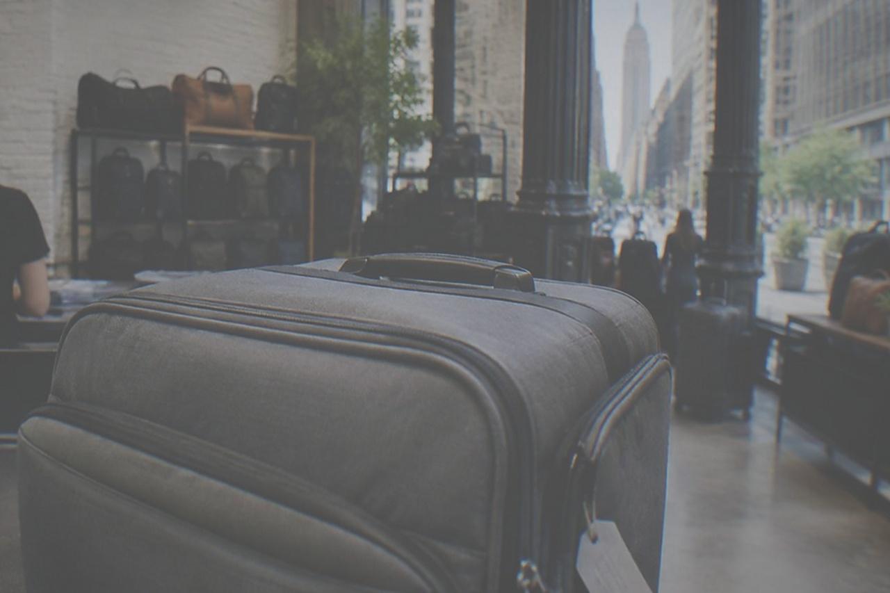 A staffed bag storage counter inside a New York shop, with suitcases lined up behind the counter