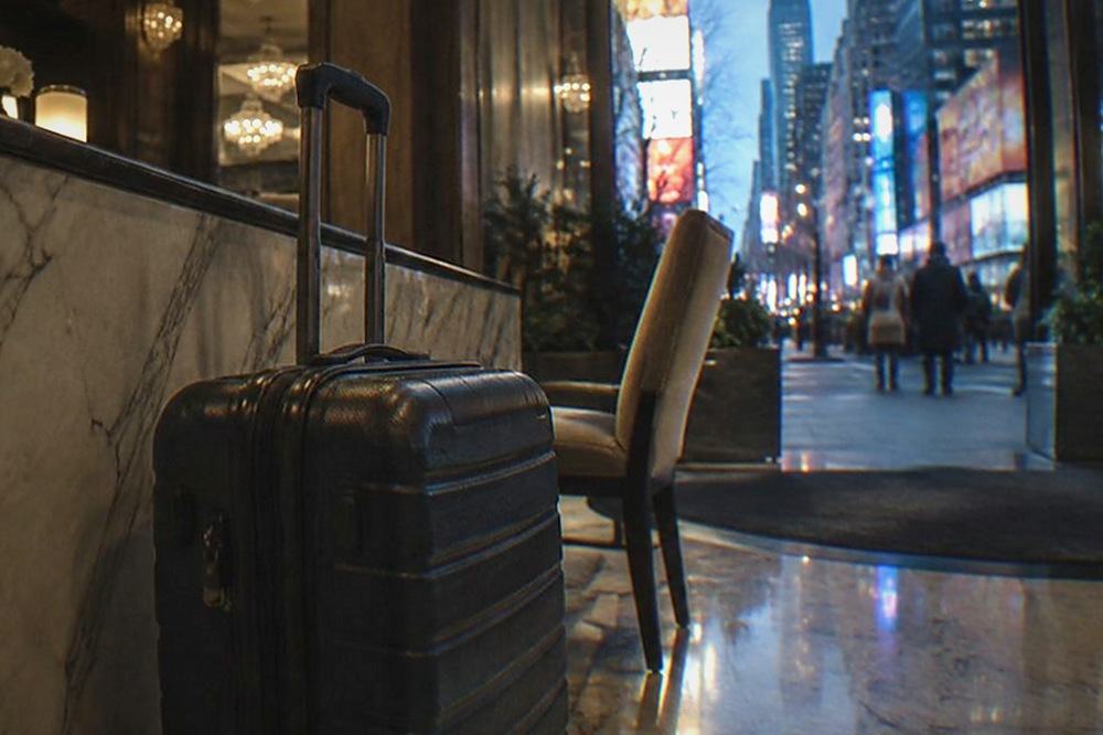Suitcase waiting beside a hotel front desk with a closed sign on the counter