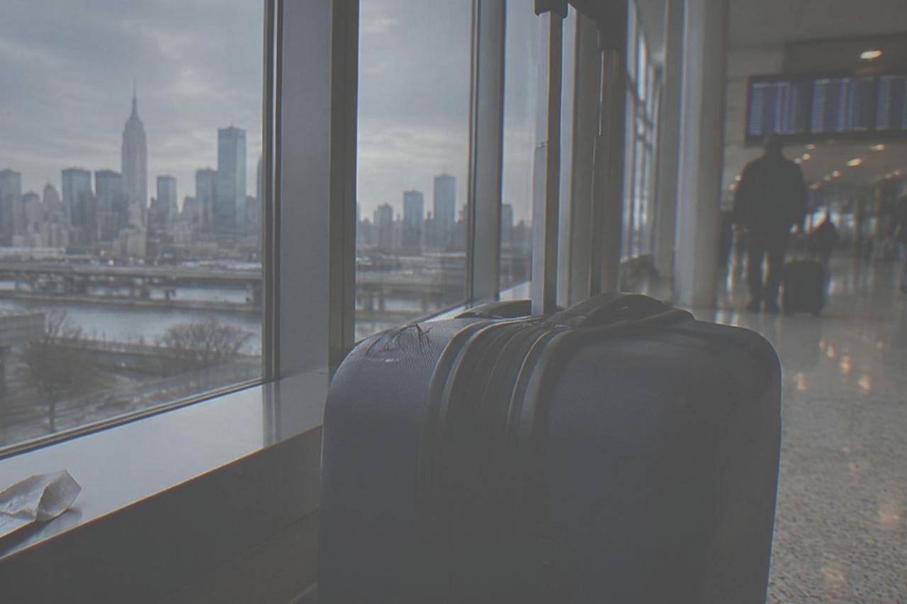 Empty airport terminal corridor with floor to ceiling windows and departure boards