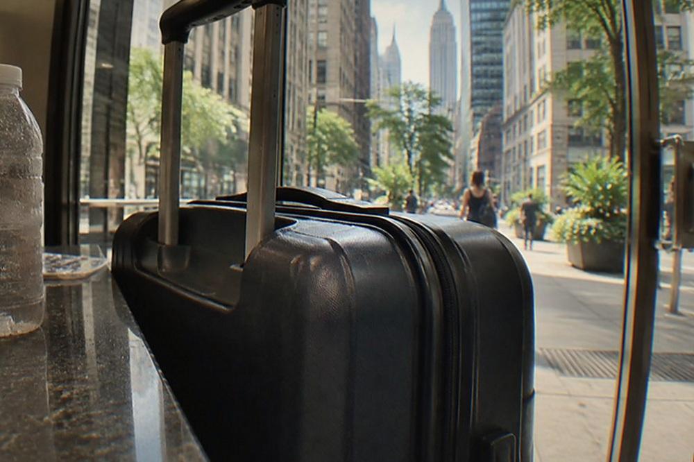 Rolling suitcase parked beside the counter of a small city shop