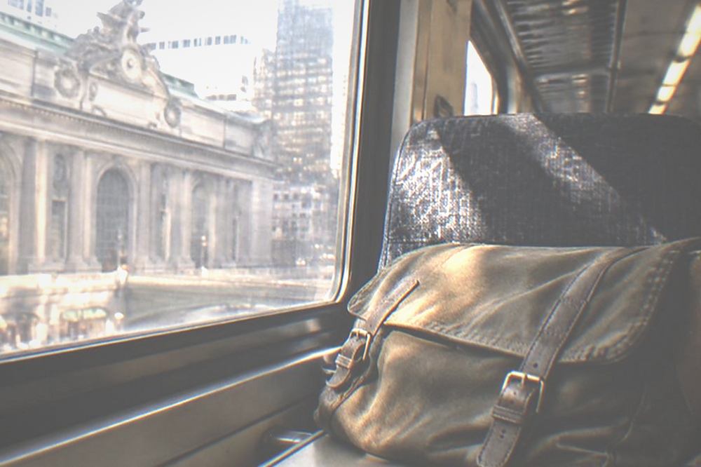A commuter train interior with empty overhead luggage racks above the seats