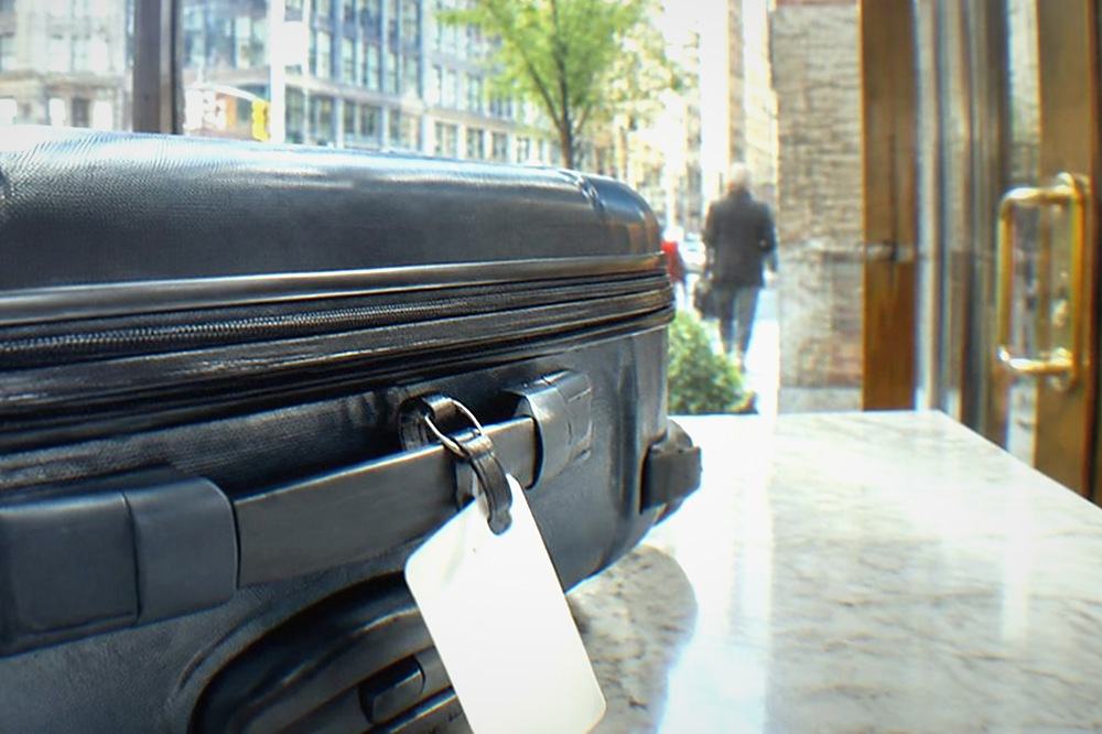 A suitcase standing beside a shop counter in a bright New York storefront