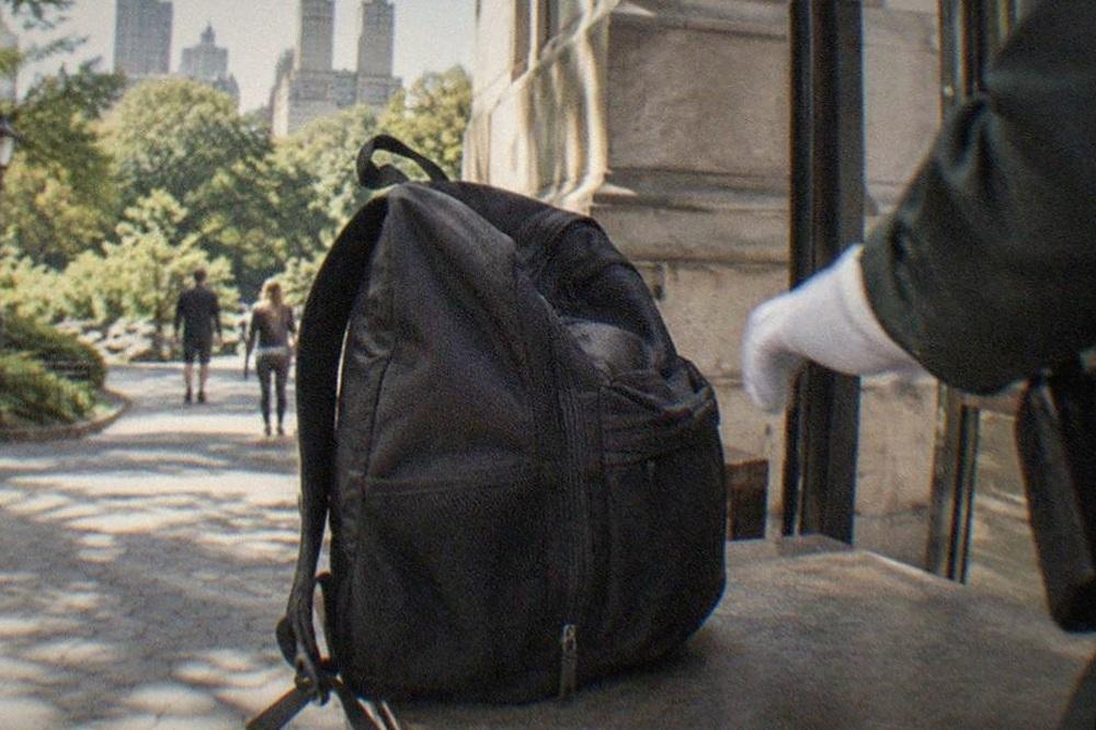 Security staff inspecting a visitor backpack at a museum entrance