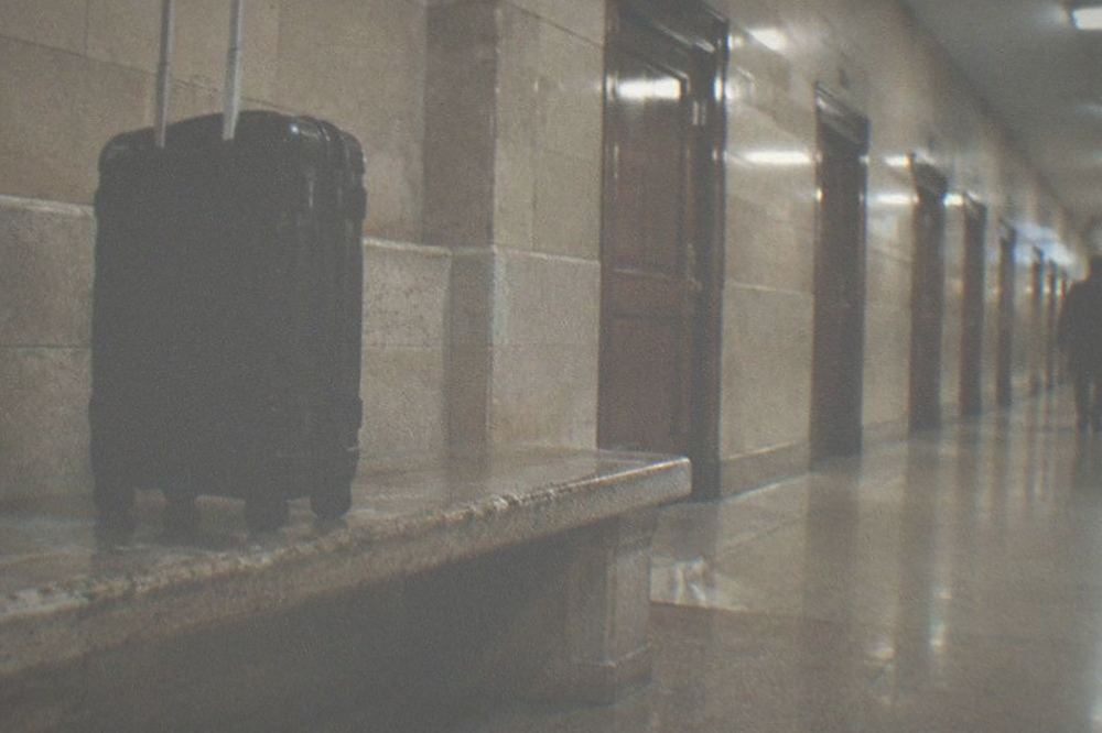 Empty corridor in a station with tiled walls and a row of closed doors