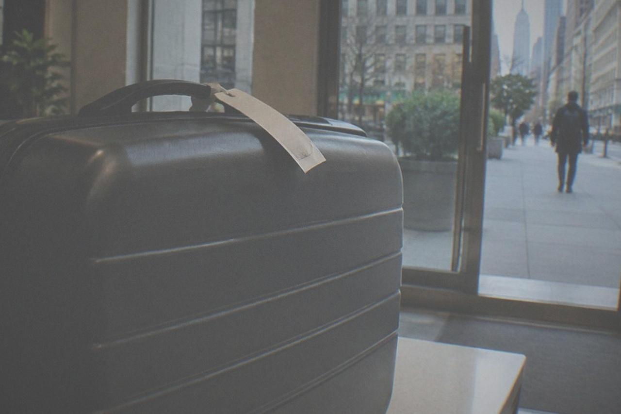 A closed suitcase sitting beside a shop counter in a bright New York interior