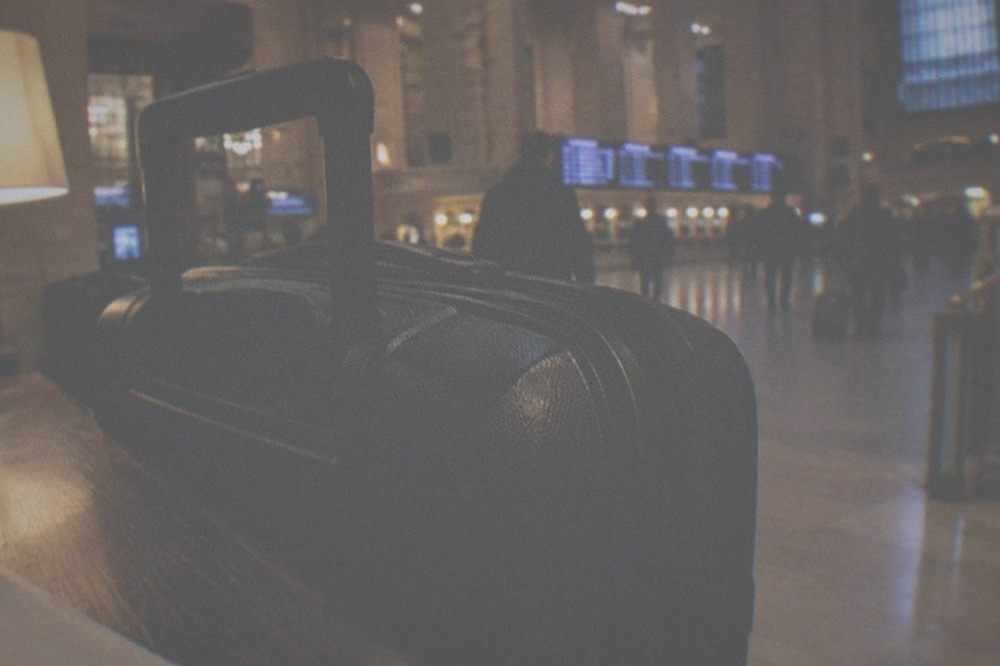 A train hall interior at night with a closed information desk and lit departure boards